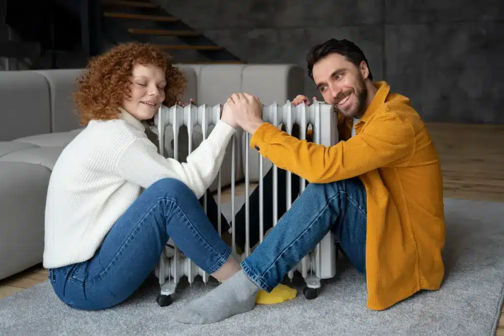 Personne ajustant un radiateur d’appoint dans un salon lumineux, montrant confort et chaleur.